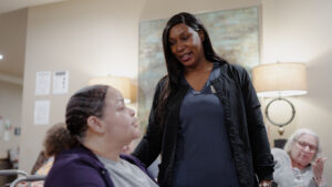 A woman nurse is speaking to a resident at Alcoa Pines.