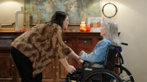 A woman is talking to another older woman in a nursing home
